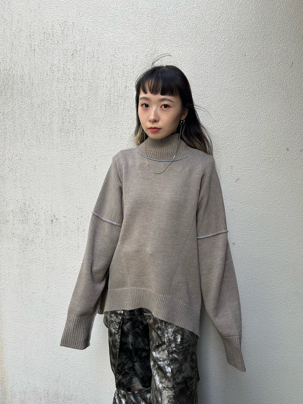 ブラック系のブーツ、ベージュ系のニット/セーター、シルバー系のその他パンツを着用したレディースの秋コーディネートの5枚目の写真
