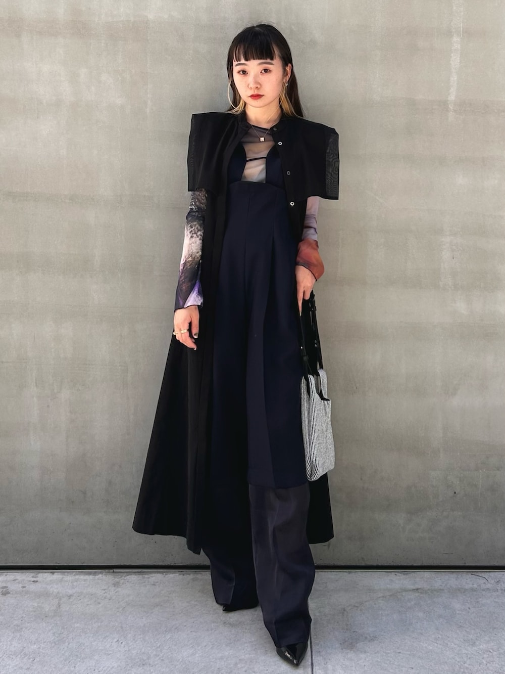 ブラック系のワンピース、シルバー系のショルダーバッグを着用したレディースの春コーディネートの5枚目の写真