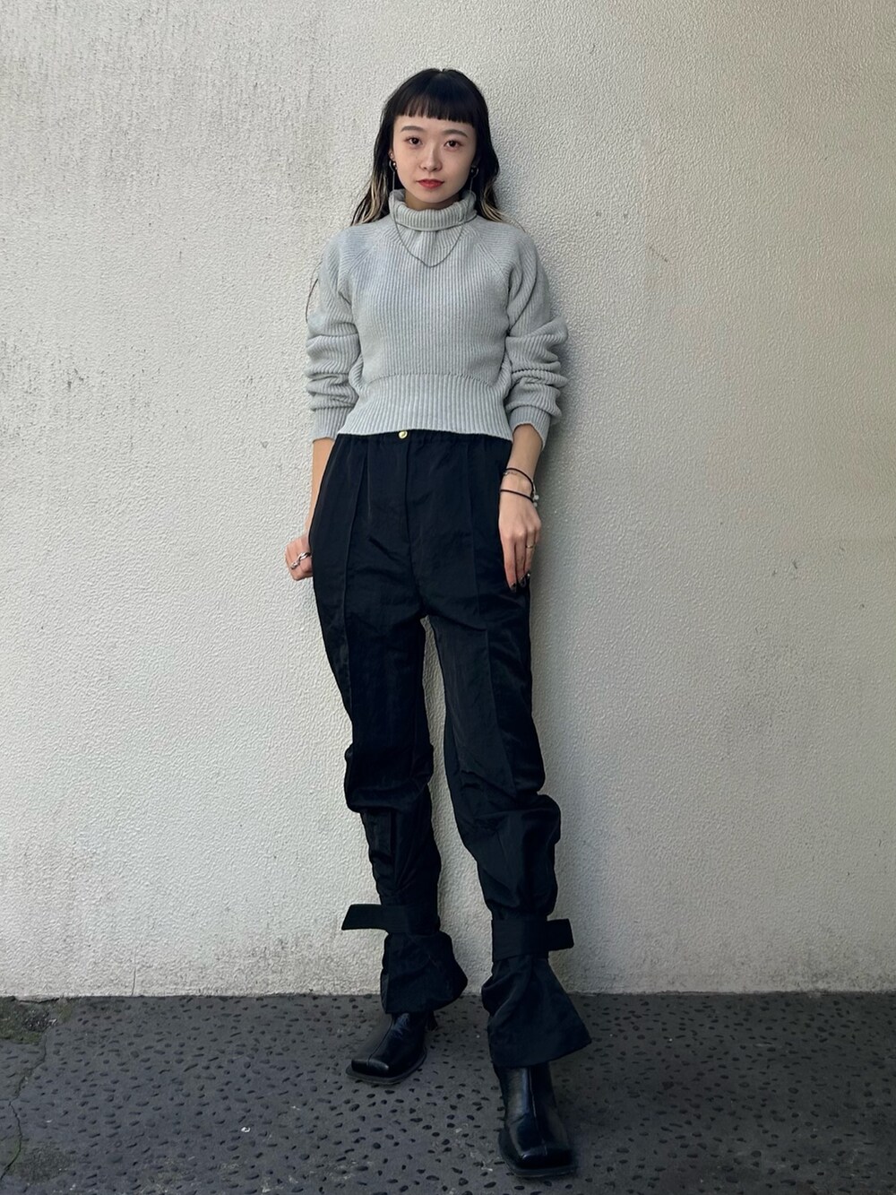 グレー系のニット/セーター、ブラック系のカーゴパンツ、ブラック系のブーツを着用したレディースの秋コーディネートの3枚目の写真