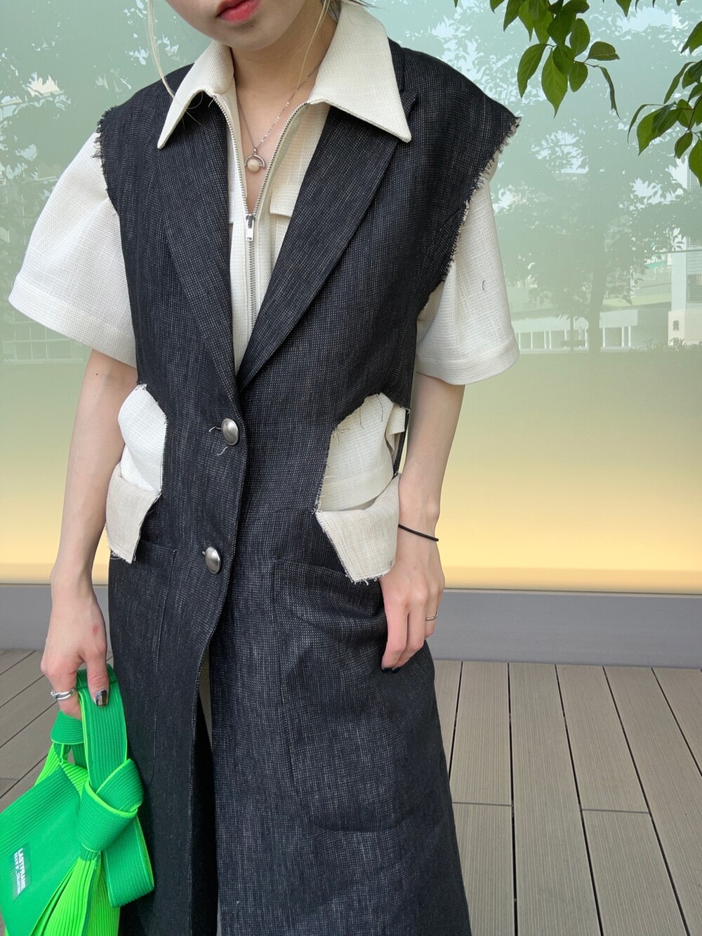 グリーン系のハンドバッグ、ホワイト系のスラックス、ホワイト系のシャツ/ブラウスを着用したレディースの春コーディネートの3枚目の写真