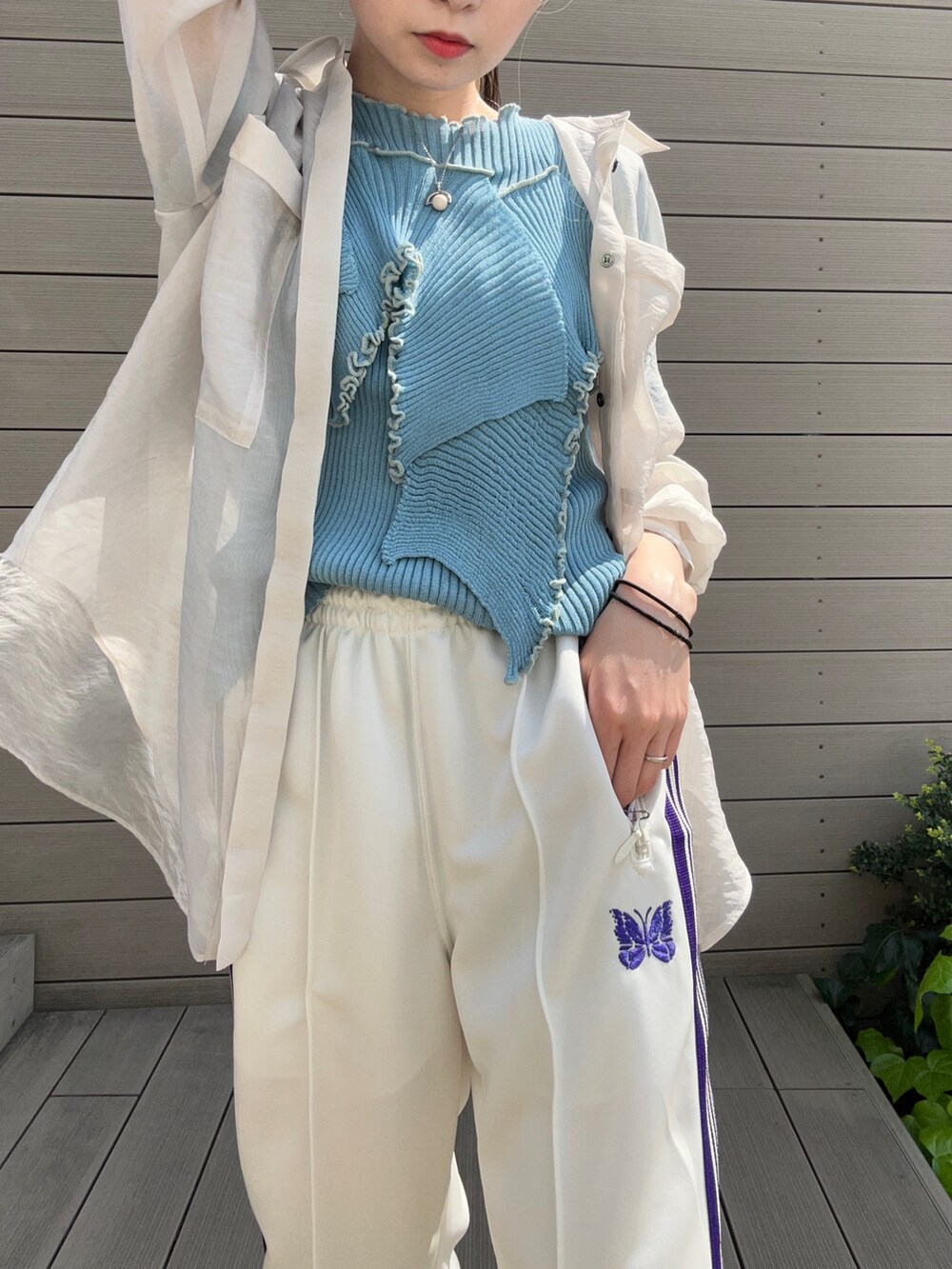 ホワイト系のシャツ/ブラウス、ブルー系のニット/セーター、シルバー系のショルダーバッグを着用したレディースの春コーディネートの4枚目の写真