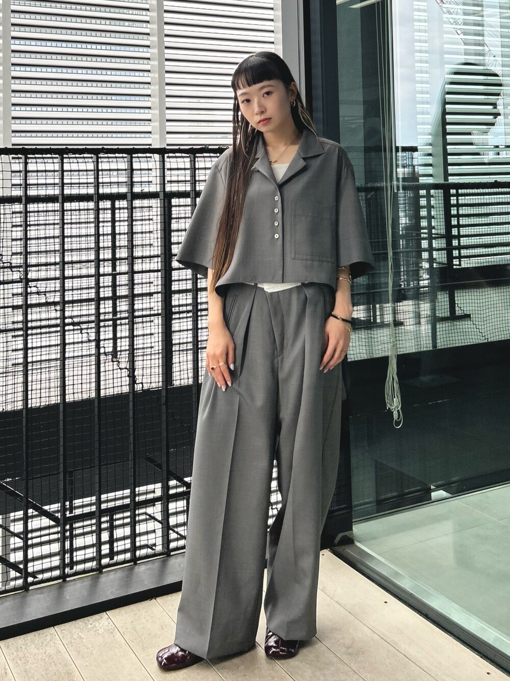 グレー系のシャツ/ブラウス、ブラック系のショルダーバッグ、ブラック系のスラックスを着用したレディースの夏コーディネートの2枚目の写真