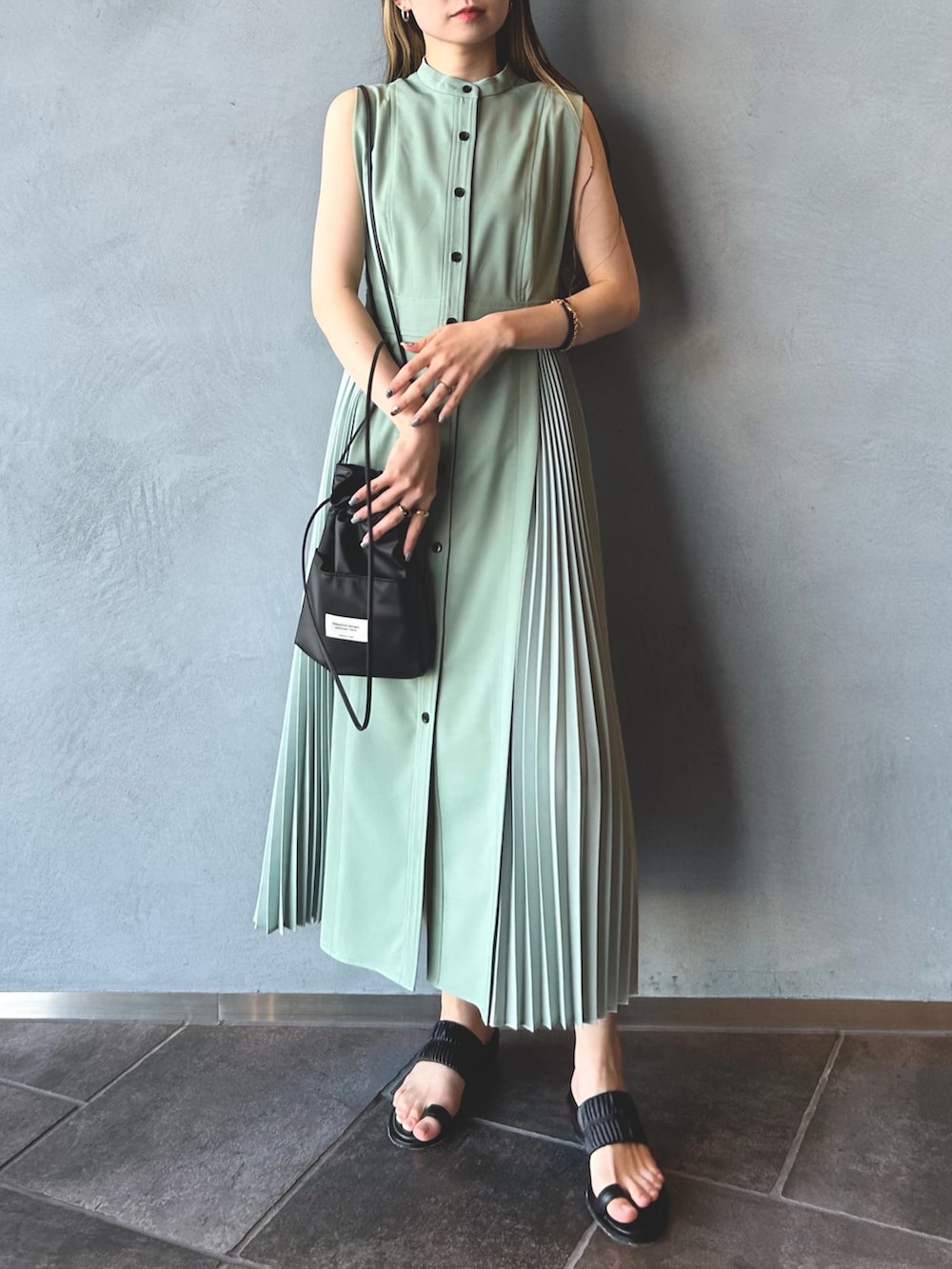 グリーン系のワンピース、ブラック系のショルダーバッグ、ブラック系のその他シューズを着用したレディースの春コーディネートの4枚目の写真