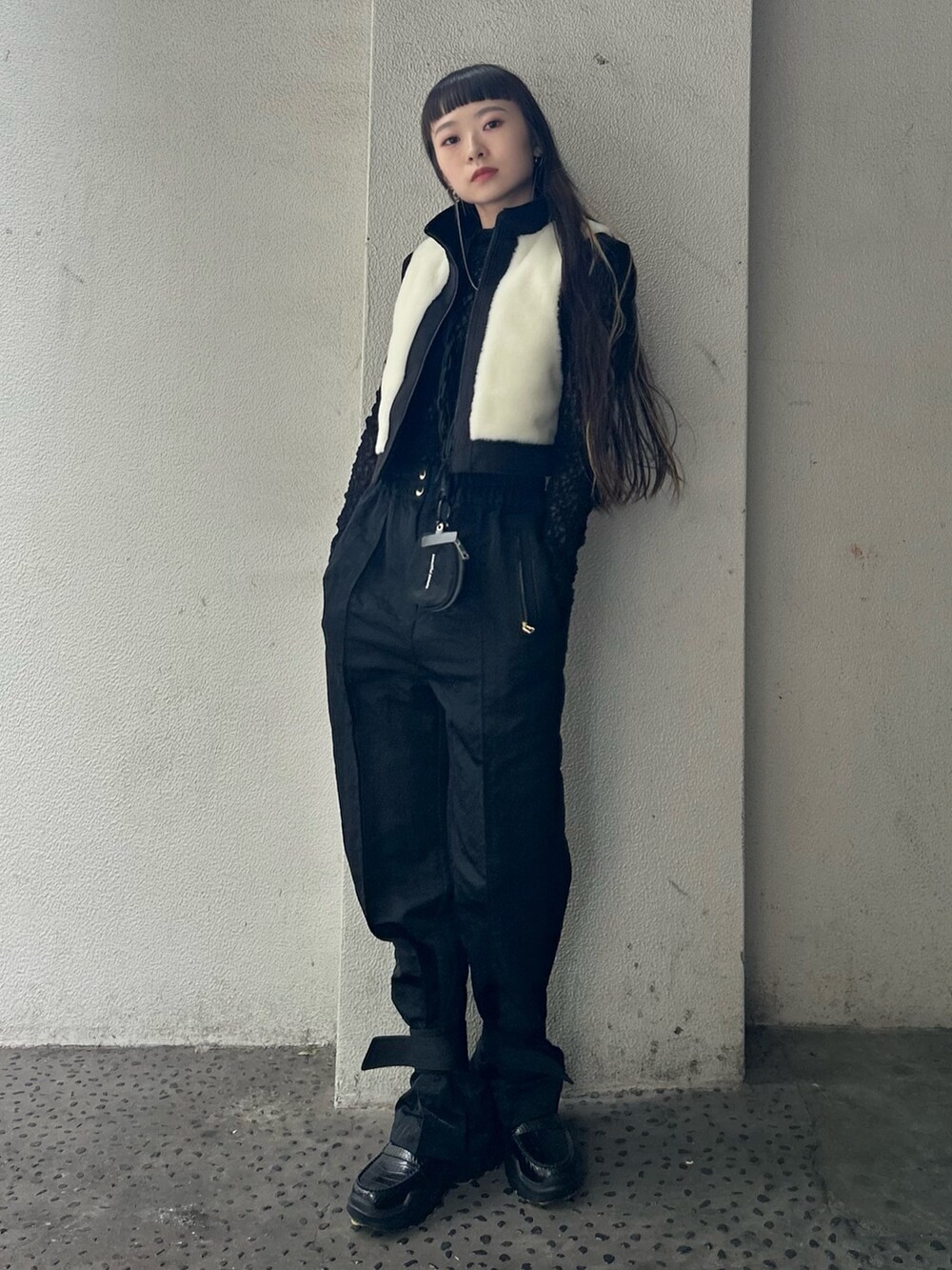 ブラック系のTシャツ/カットソー、ブラック系のカーゴパンツ、ブラック系のスマホグッズを着用したレディースの秋コーディネートの3枚目の写真