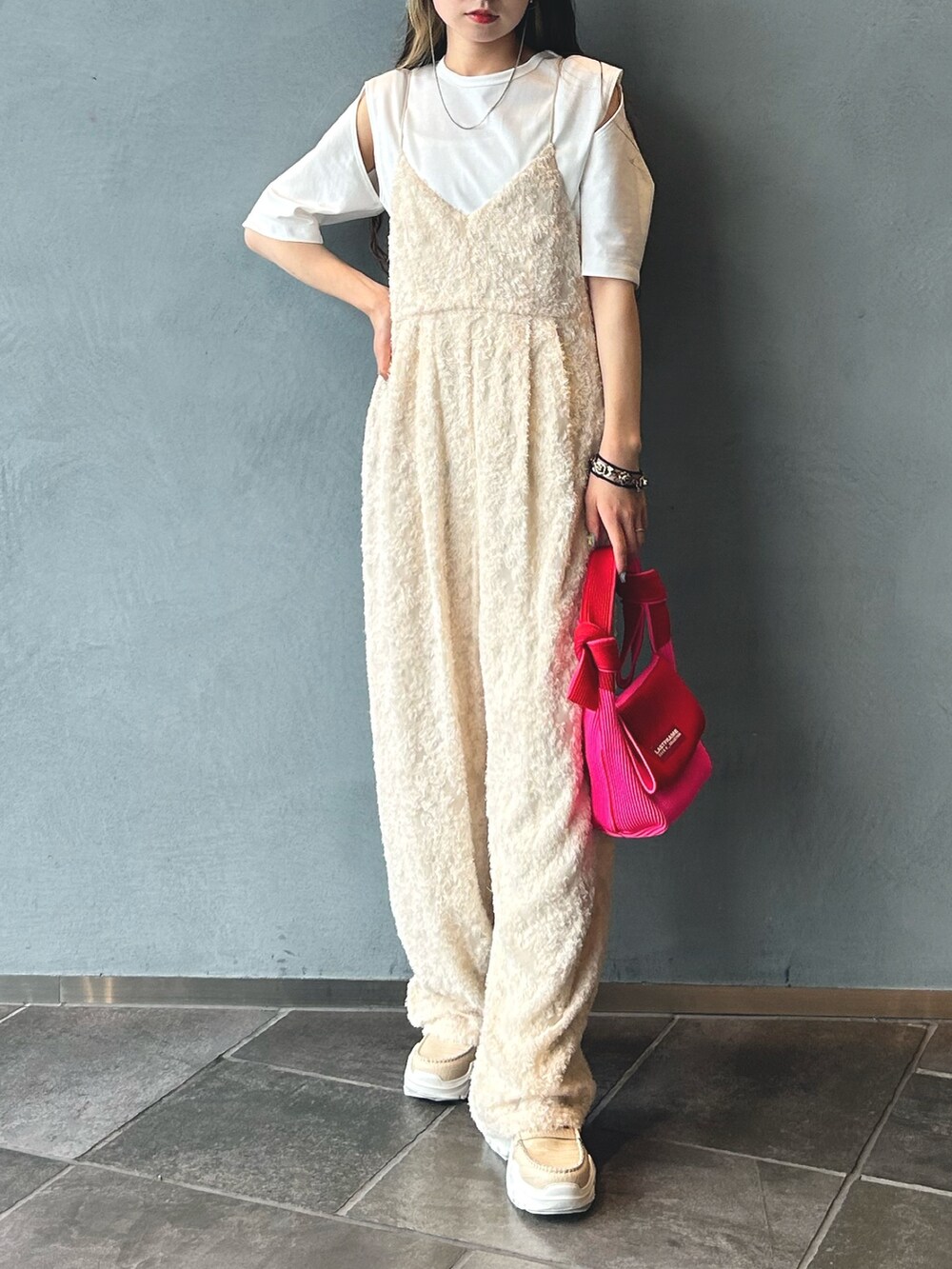レッド系のハンドバッグ、ホワイト系のつなぎ/オールインワン、ホワイト系のTシャツ/カットソーを着用したレディースの春コーディネートの3枚目の写真