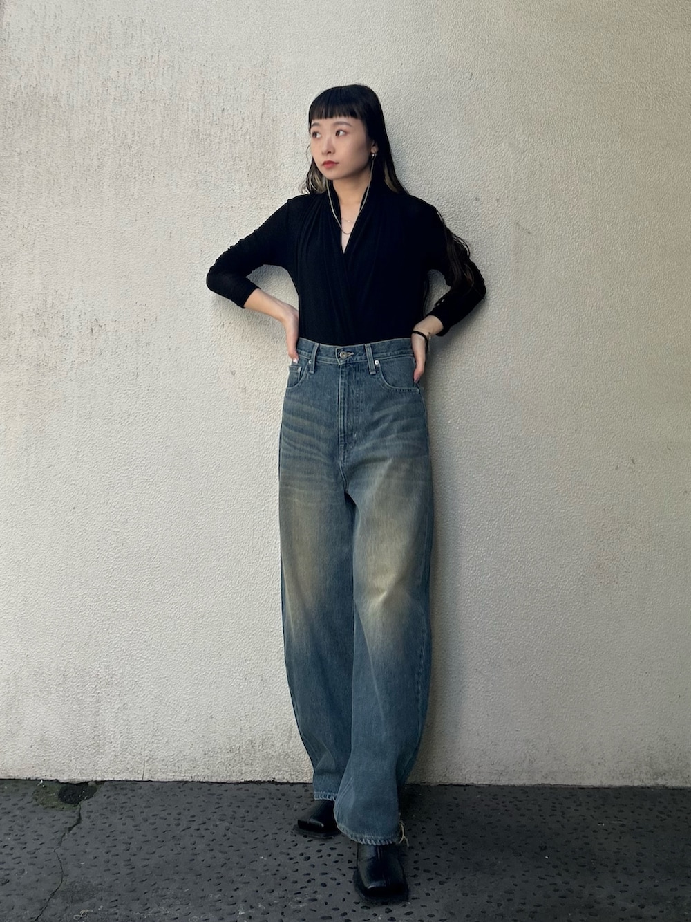 ブルー系のデニムパンツ、ブラック系のブーツを着用したレディースの秋コーディネートの2枚目の写真