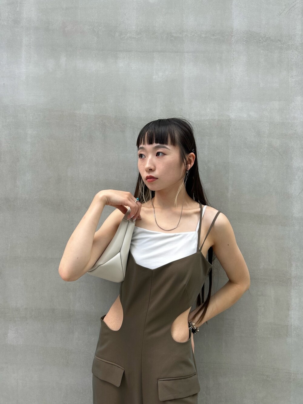 グリーン系のつなぎ/オールインワン、ベージュ系のハンドバッグを着用したレディースの夏コーディネートの4枚目の写真