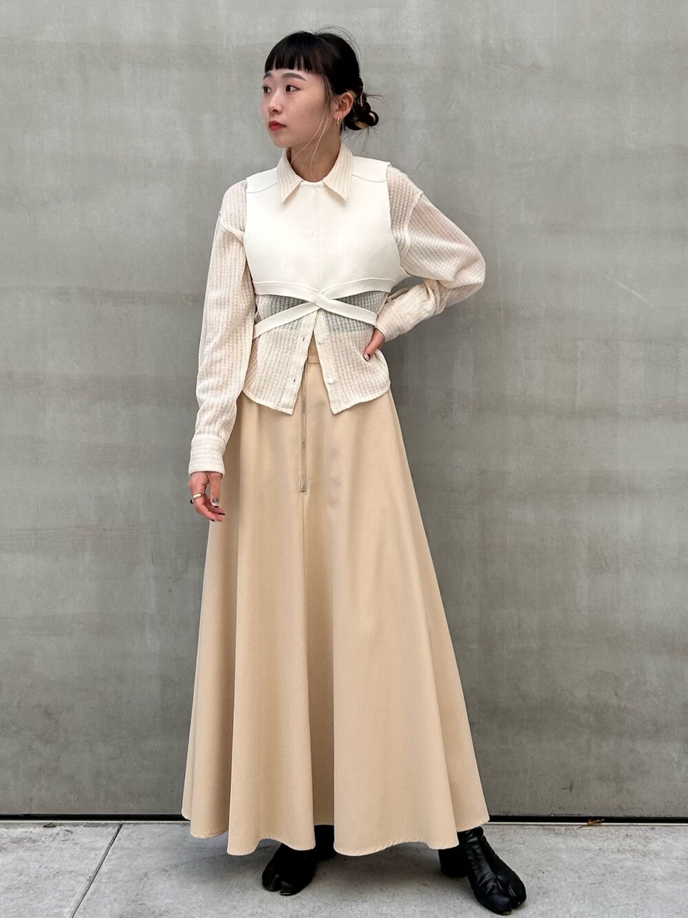 ベージュ系のスカート、ホワイト系のシャツ/ブラウス、ホワイト系のTシャツ/カットソーを着用したレディースの春コーディネートの3枚目の写真