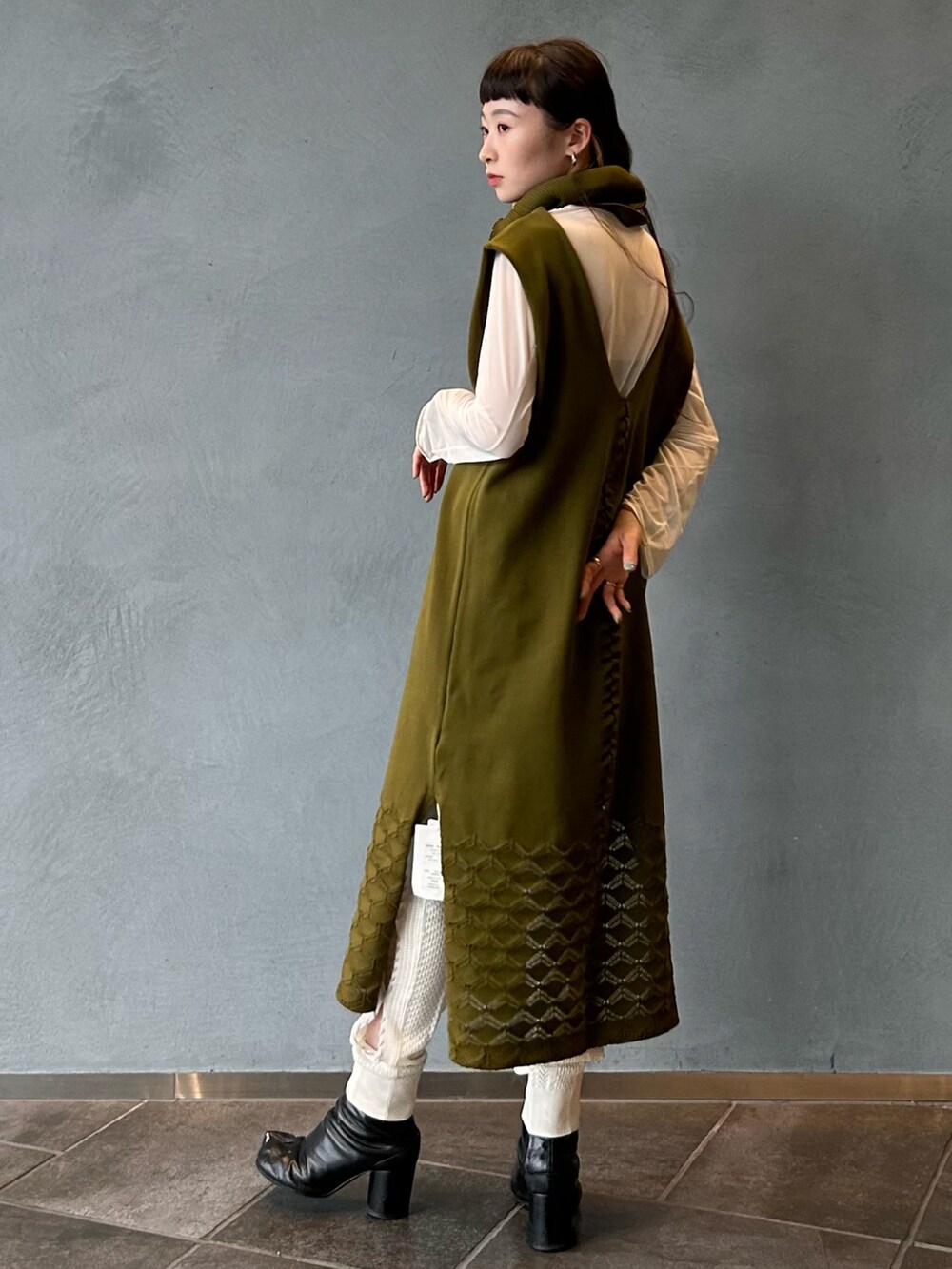 グリーン系のドレスを着用したレディースの春コーディネートの6枚目の写真