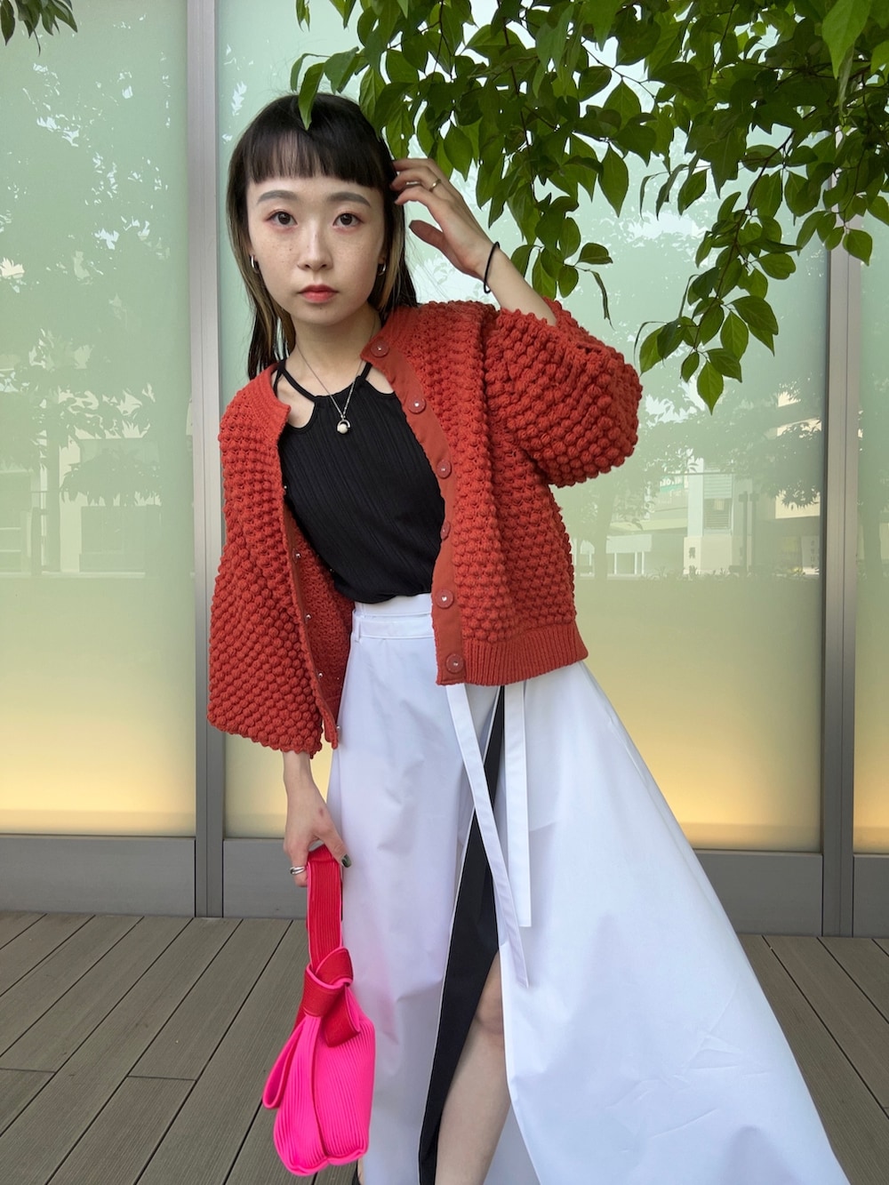 レッド系のカーディガン/ボレロ、ホワイト系のスカートを着用したレディースの春コーディネートの4枚目の写真