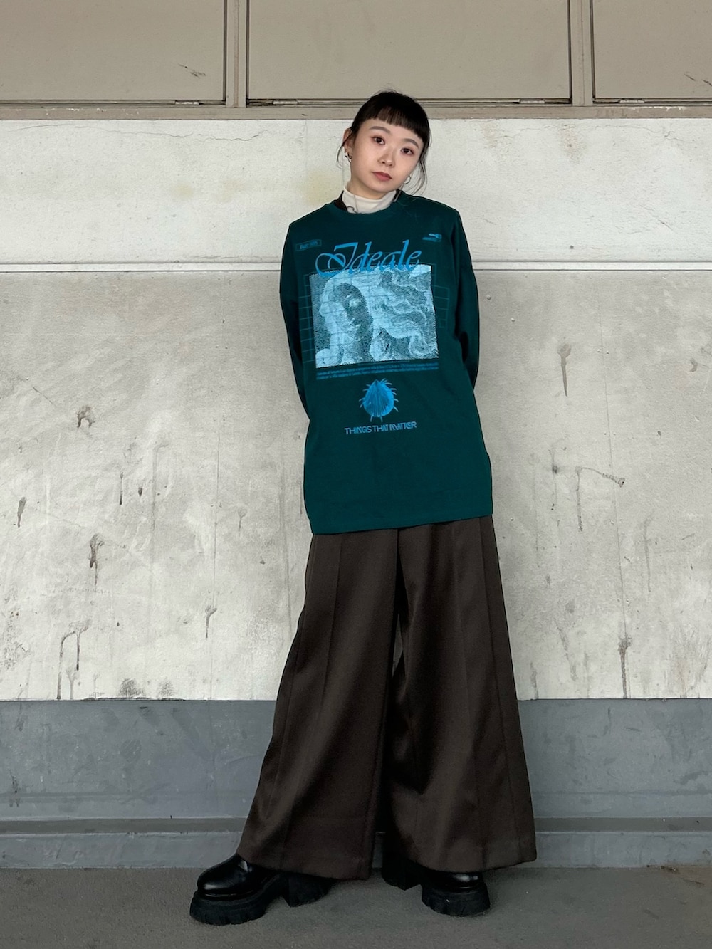 グリーン系のTシャツ/カットソー、ベージュ系のTシャツ/カットソー、ブラック系のブーツを着用したレディースの秋コーディネートの3枚目の写真