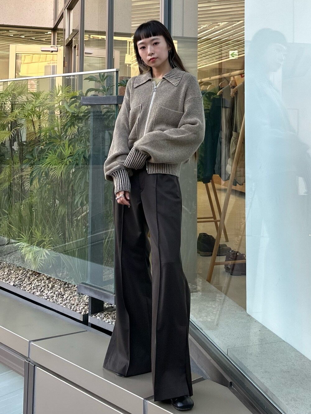 ブラウン系のスラックス、ブラック系のブーツを着用したレディースの秋コーディネートの4枚目の写真