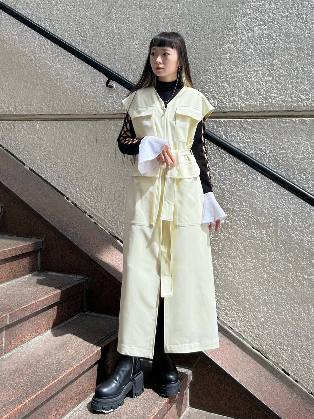 ベージュ系のワンピース、ブラック系のブーツを着用したレディースの秋コーディネートの2枚目の写真