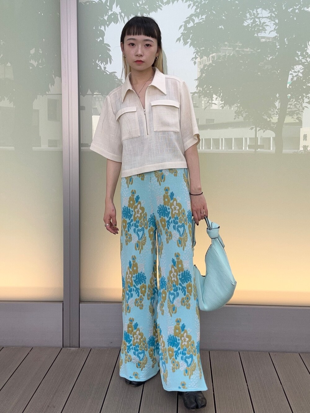 ブルー系のその他パンツ、ホワイト系のシャツ/ブラウス、グリーン系のハンドバッグを着用したレディースの春コーディネートの2枚目の写真