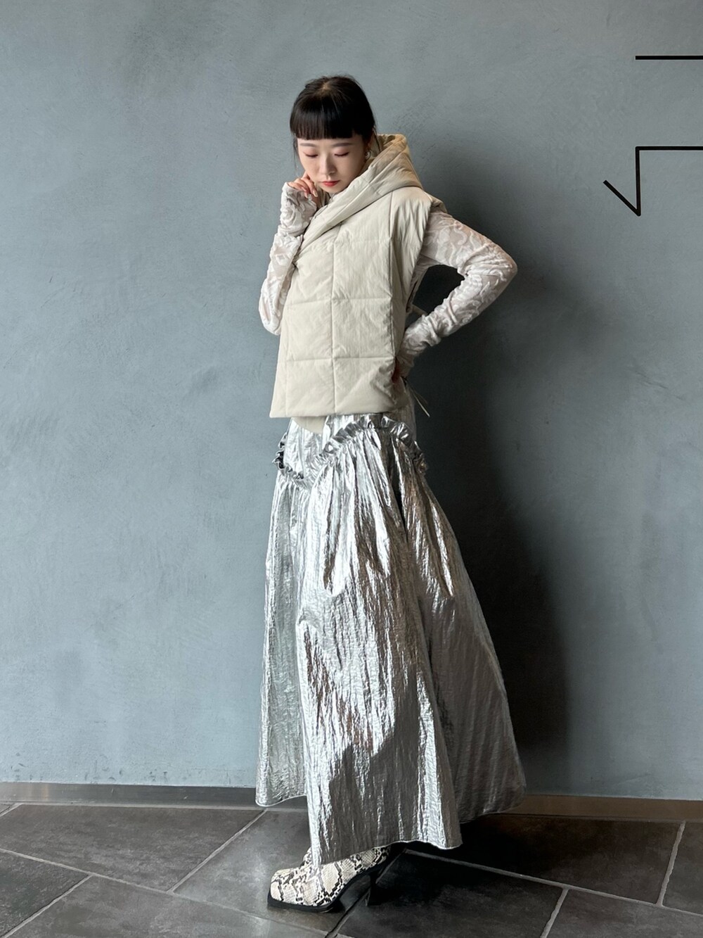 その他のブーツ、ホワイト系のTシャツ/カットソー、シルバー系のスカートを着用したレディースの秋コーディネートの4枚目の写真