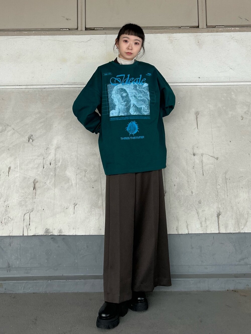 グリーン系のTシャツ/カットソー、ベージュ系のTシャツ/カットソー、ブラック系のブーツを着用したレディースの秋コーディネートの4枚目の写真