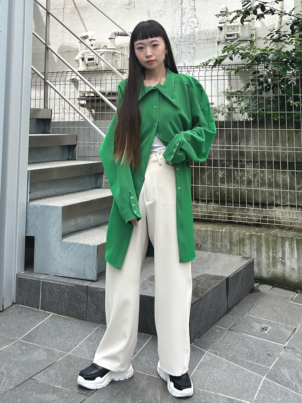 ホワイト系のスラックスを着用したレディースの夏コーディネートの3枚目の写真