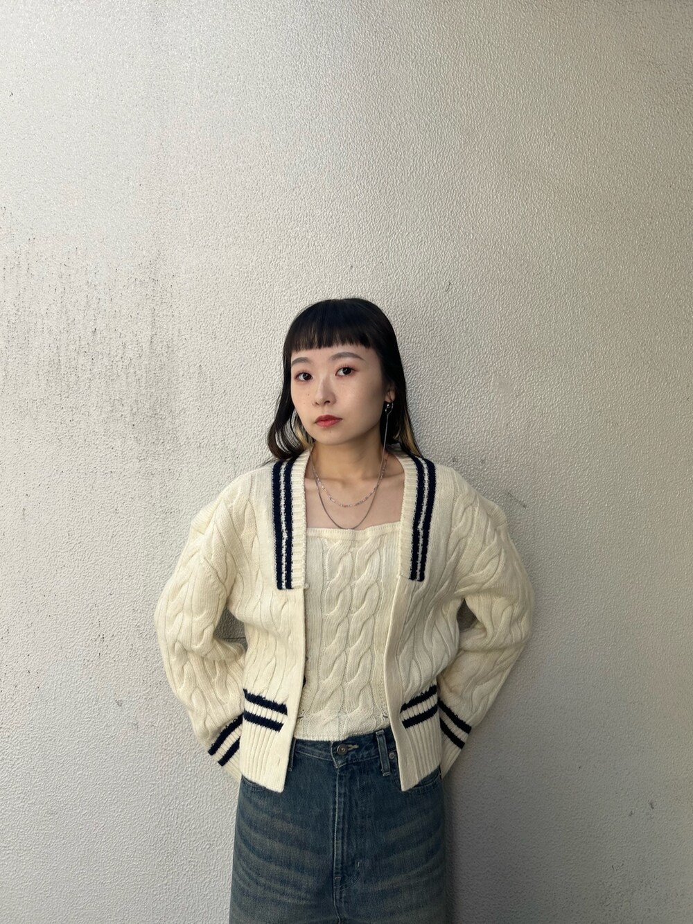 ブルー系のデニムパンツ、ホワイト系のニット/セーター、ブラック系のブーツを着用したレディースの秋コーディネートの4枚目の写真