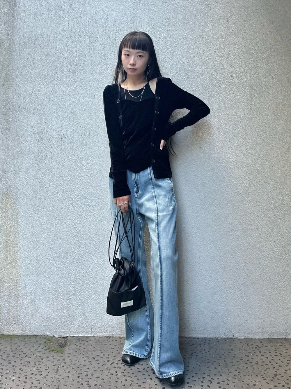 ブラック系のブーツ、ブラック系のショルダーバッグ、ブルー系のデニムパンツを着用したレディースの夏コーディネートの3枚目の写真
