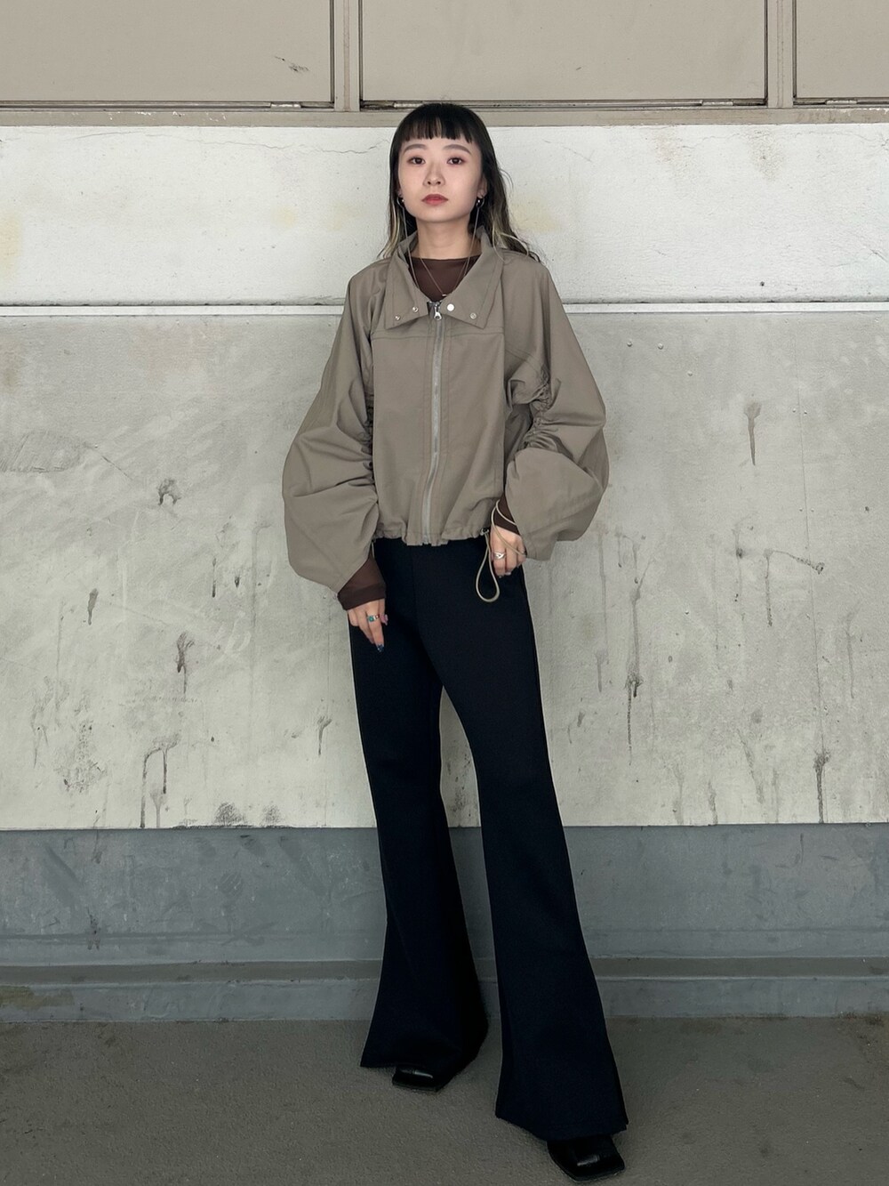 ブラウン系のTシャツ/カットソー、グリーン系のブルゾン、ブラック系のブーツを着用したレディースの秋コーディネートの5枚目の写真
