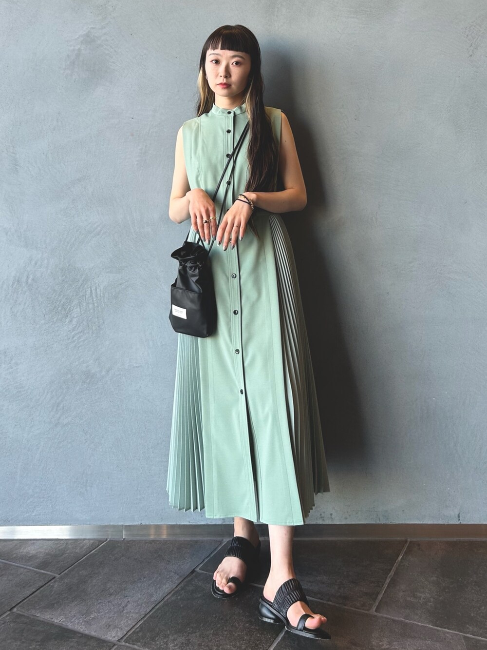 グリーン系のワンピース、ブラック系のショルダーバッグ、ブラック系のその他シューズを着用したレディースの春コーディネートの3枚目の写真