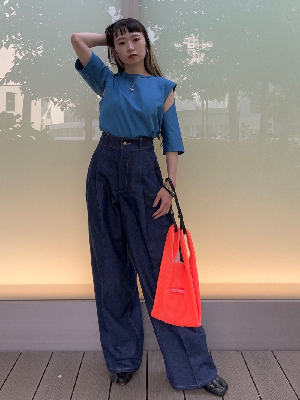 ブルー系のTシャツ/カットソー、オレンジ系のハンドバッグを着用したレディースの春コーディネートの2枚目の写真
