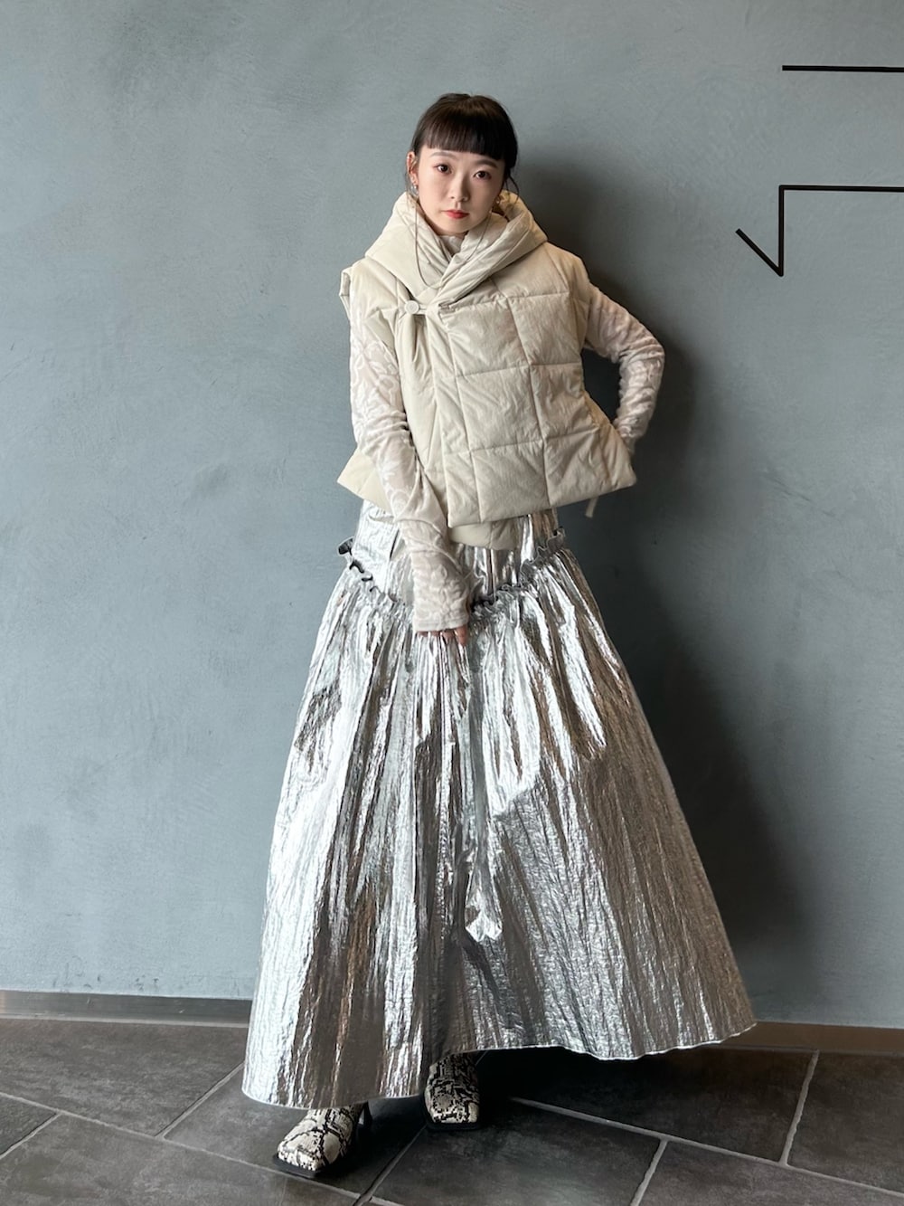 その他のブーツ、ホワイト系のTシャツ/カットソー、シルバー系のスカートを着用したレディースの秋コーディネートの2枚目の写真