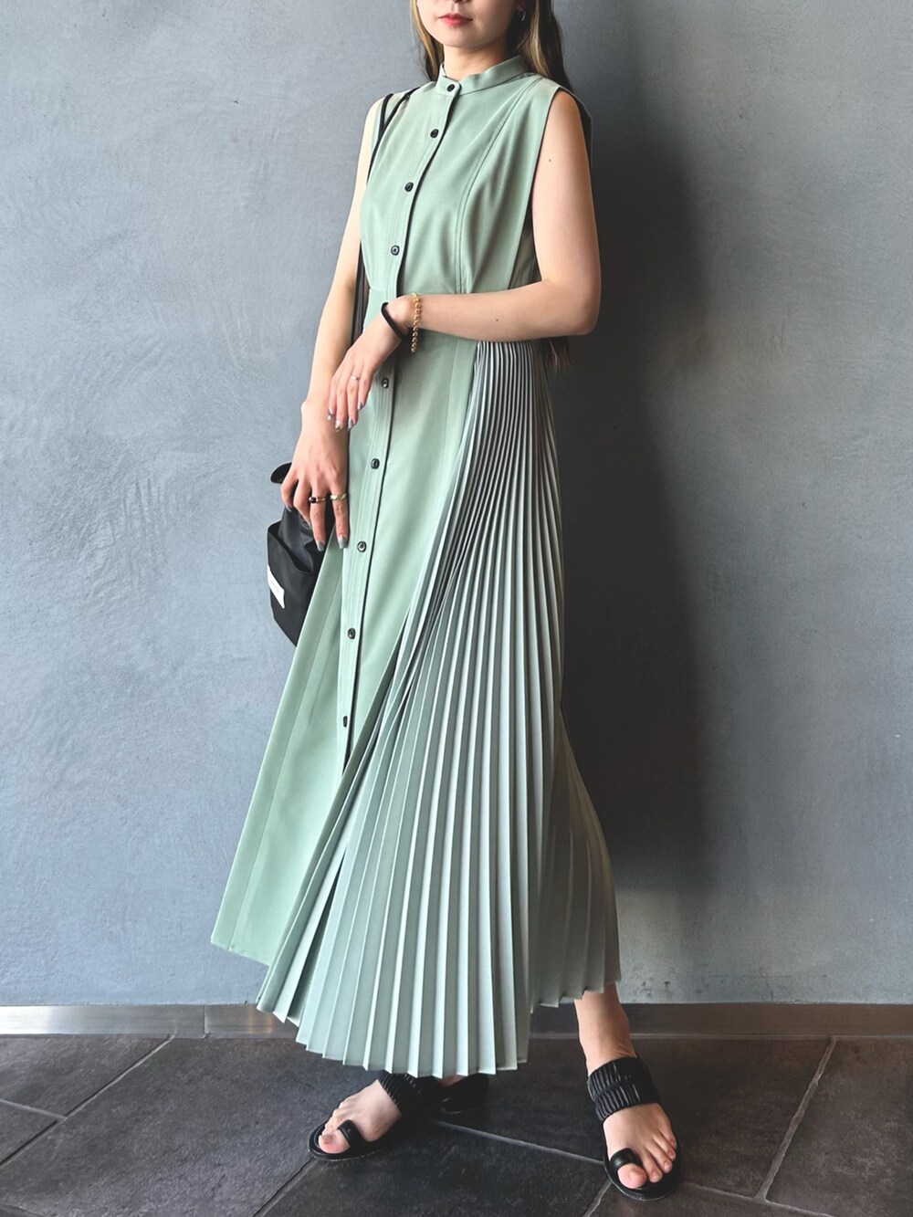 グリーン系のワンピース、ブラック系のショルダーバッグ、ブラック系のその他シューズを着用したレディースの春コーディネートの2枚目の写真