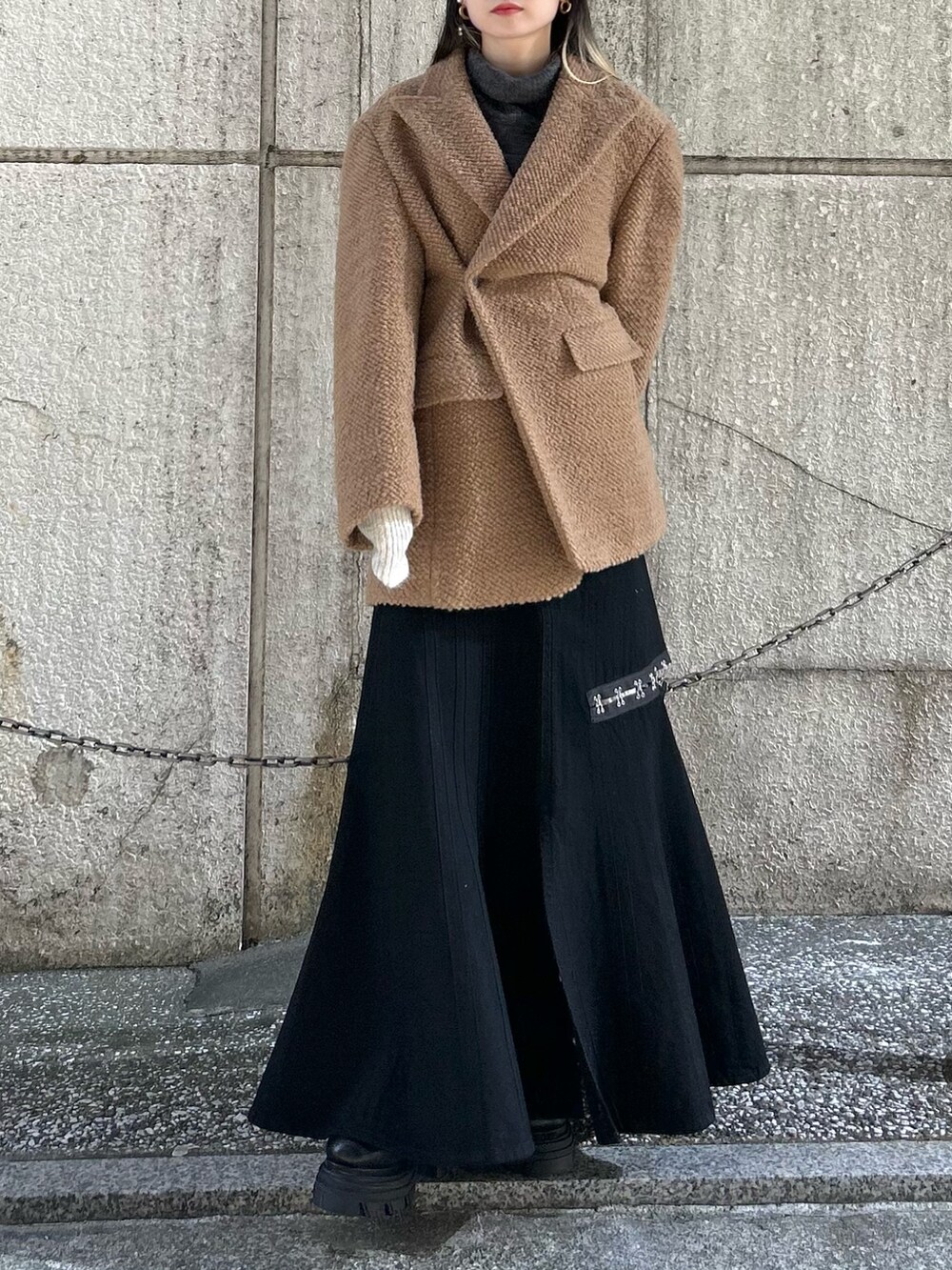 ブラック系のスカート、イエロー系のその他アウター、グリーン系のニット/セーターを着用したレディースの冬コーディネートの5枚目の写真