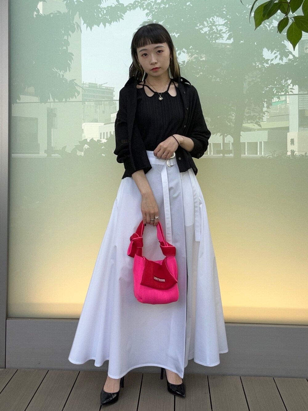 ブラック系のシャツ/ブラウス、ホワイト系のスカート、レッド系のハンドバッグを着用したレディースの春コーディネートの2枚目の写真