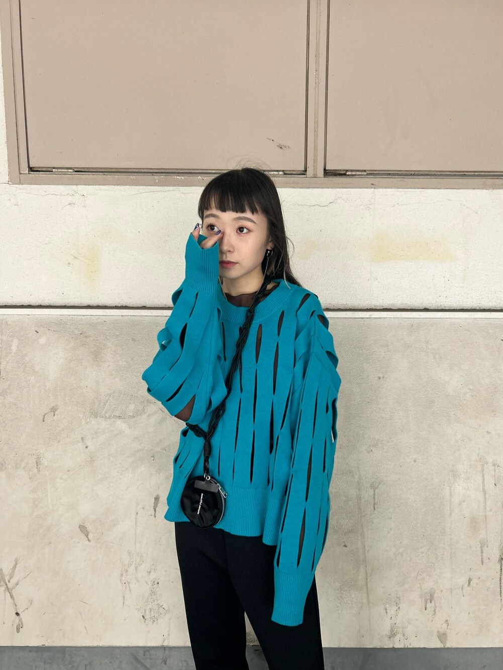 ブラウン系のTシャツ/カットソー、ブルー系のニット/セーター、ブラック系のスマホグッズを着用したレディースの秋コーディネートの5枚目の写真