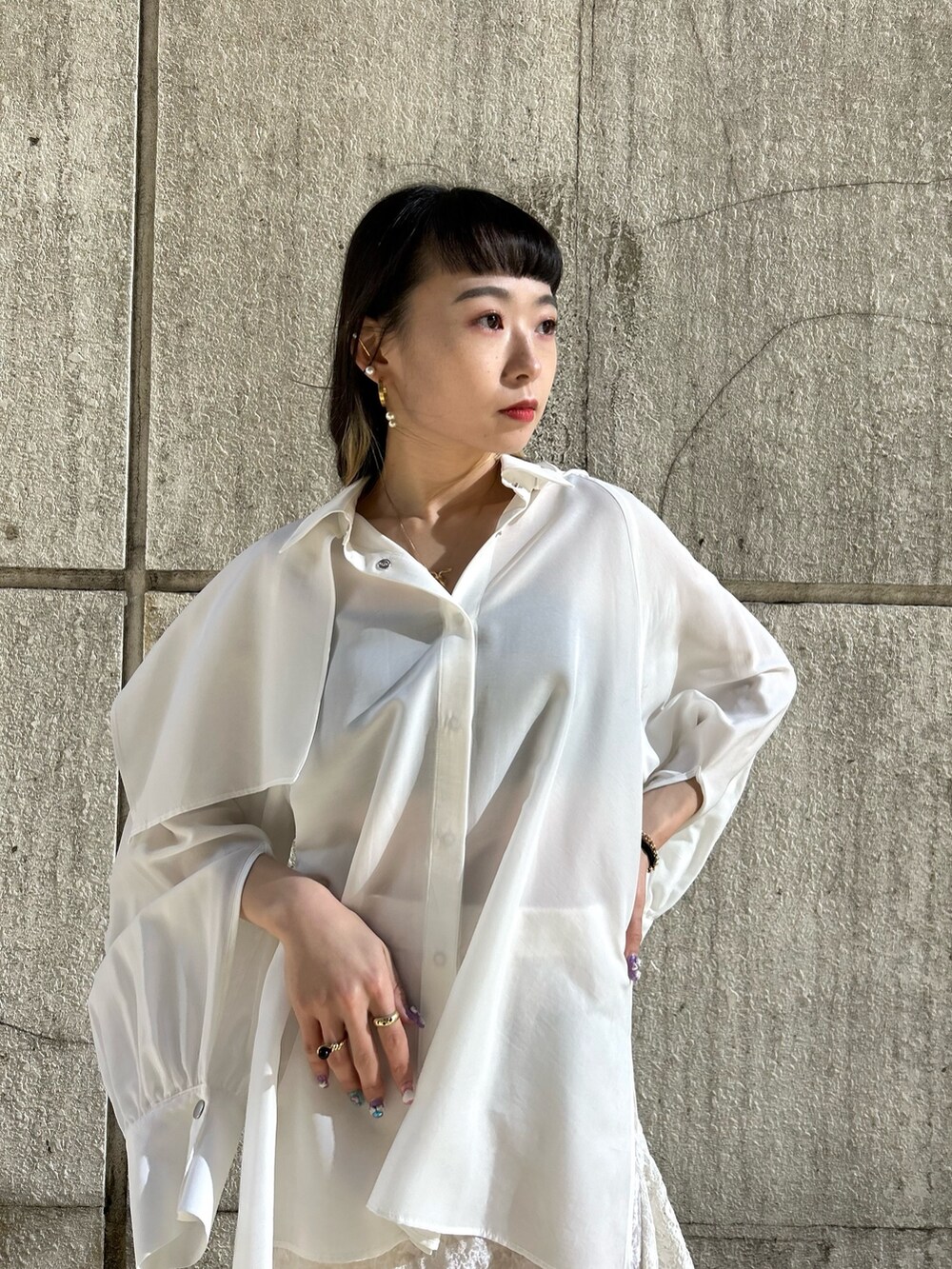 ホワイト系のスカート、ホワイト系のシャツ/ブラウス、ブラック系のブーツを着用したレディースの冬コーディネートの3枚目の写真