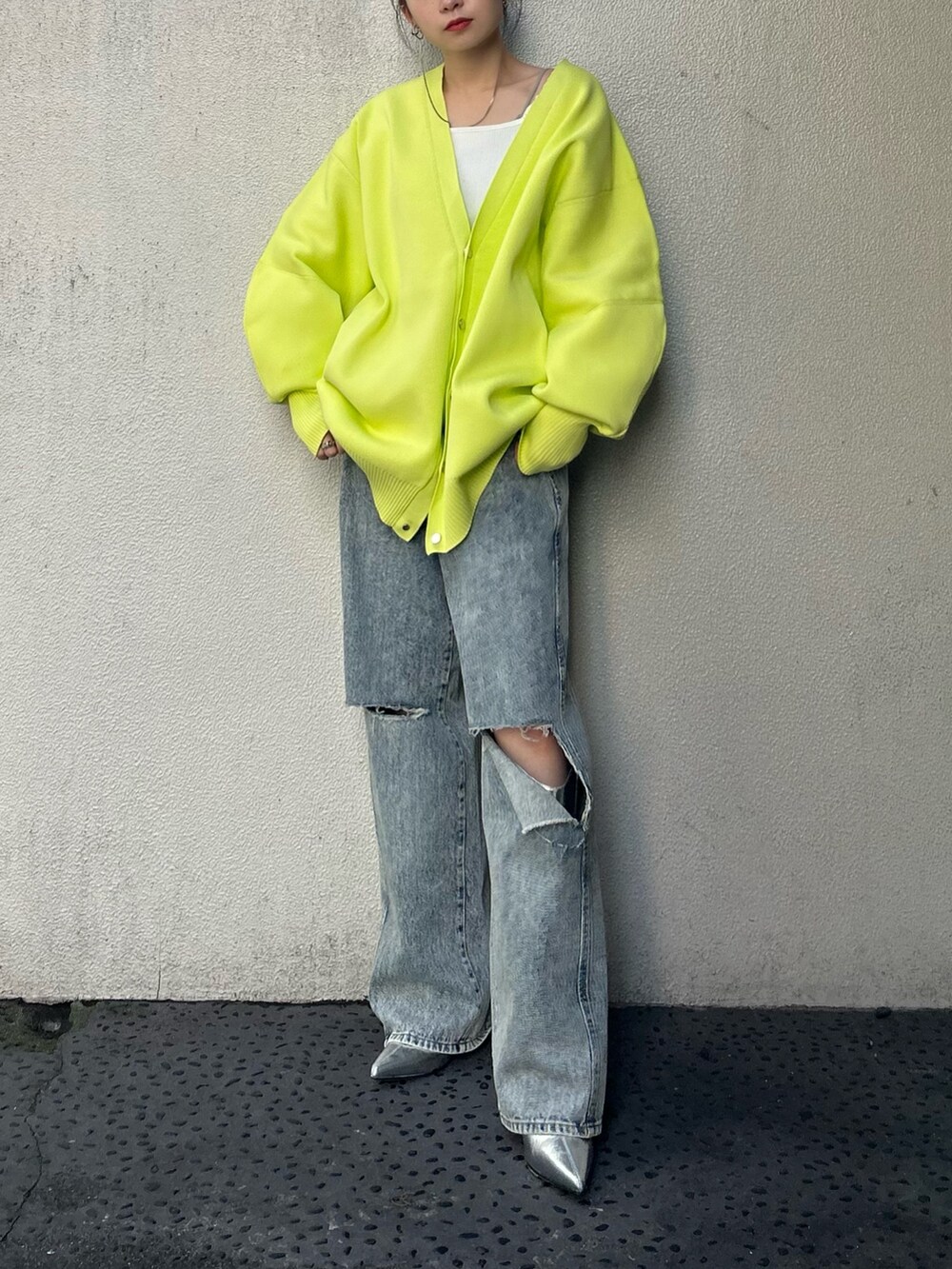 イエロー系のカーディガン/ボレロ、ブルー系のデニムパンツ、シルバー系のブーツを着用したレディースの冬コーディネートの5枚目の写真