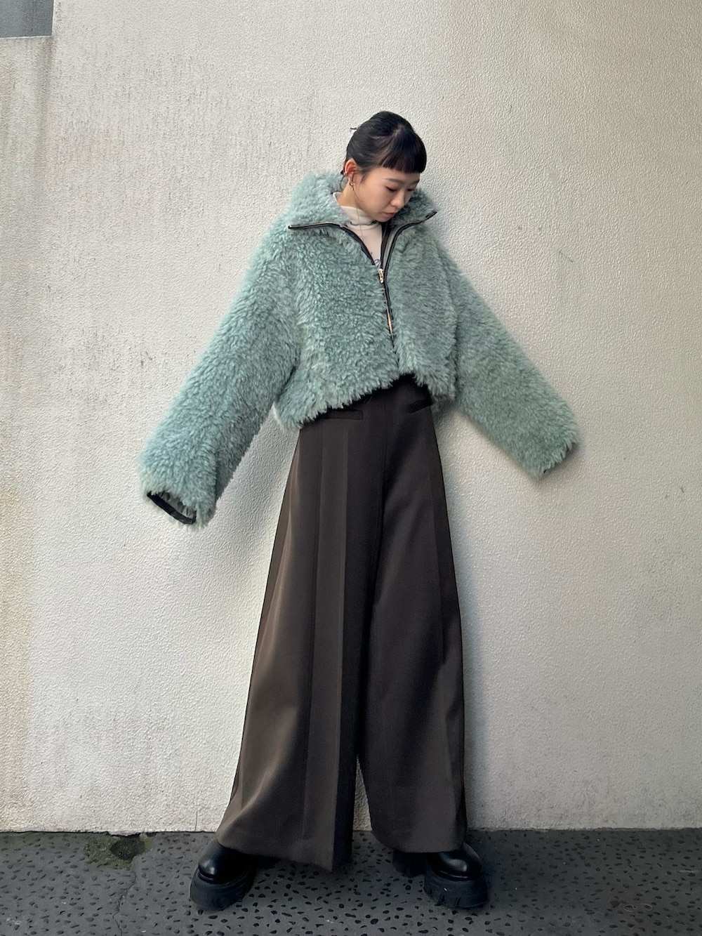 ブラック系のブーツ、ベージュ系のTシャツ/カットソー、グリーン系のブルゾンを着用したレディースの秋コーディネートの2枚目の写真