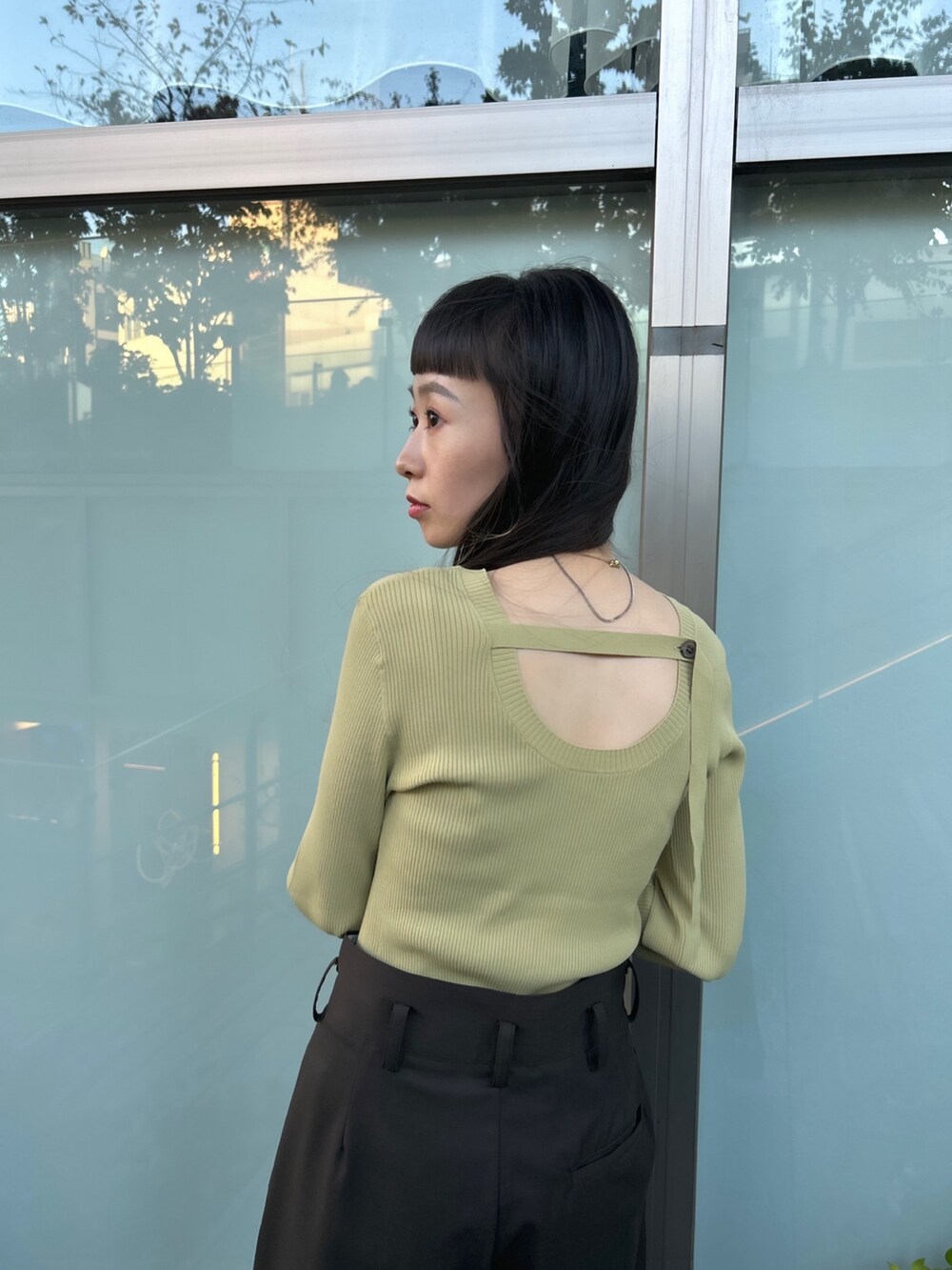 ブラウン系のスラックス、ベージュ系のニット/セーター、ブラック系のブーツを着用したレディースの秋コーディネートの5枚目の写真