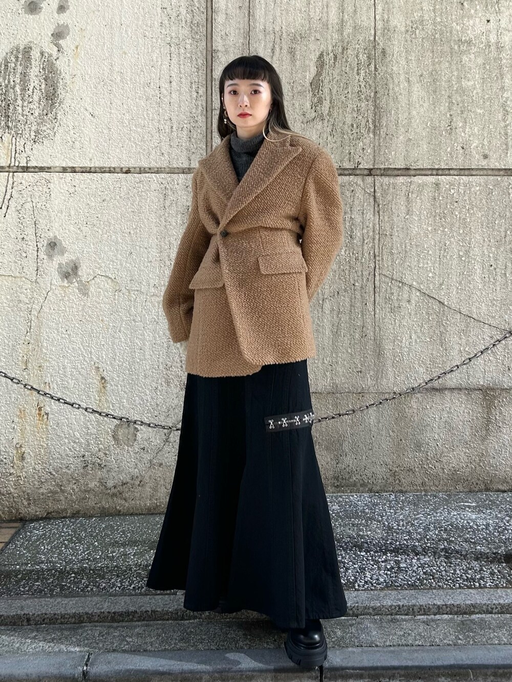 ブラック系のスカート、イエロー系のその他アウター、グリーン系のニット/セーターを着用したレディースの冬コーディネートの2枚目の写真