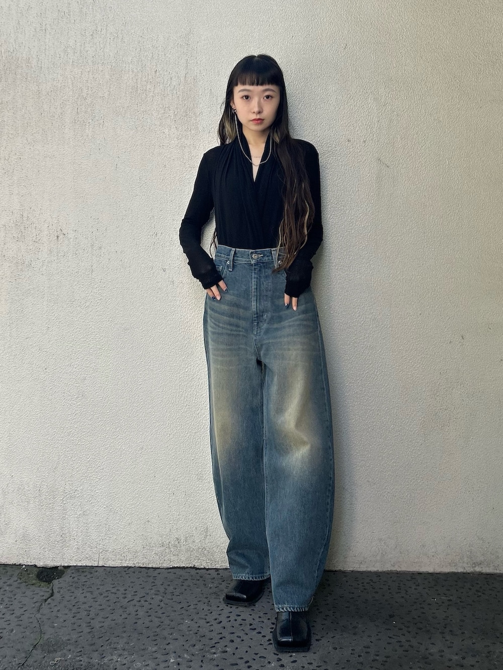 ブルー系のデニムパンツ、ブラック系のブーツを着用したレディースの秋コーディネートの4枚目の写真