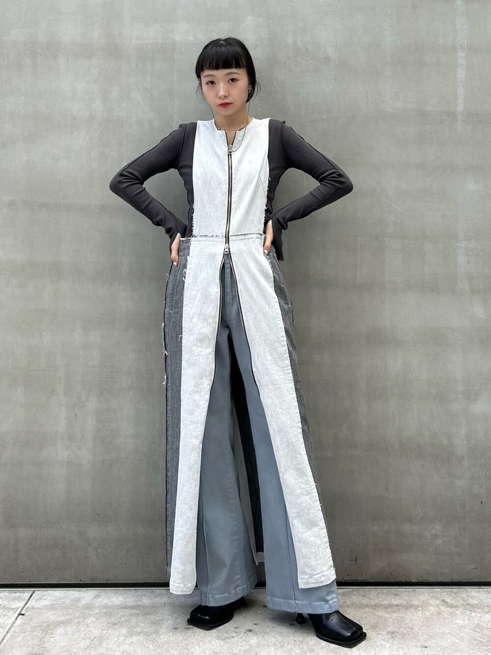 グレー系のTシャツ/カットソー、ブラック系のブーツ、ブルー系のデニムパンツを着用したレディースの秋コーディネートの2枚目の写真