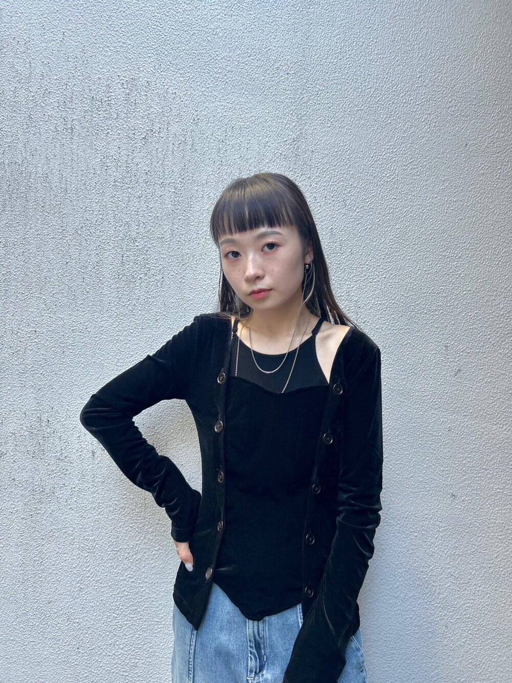 ブラック系のブーツ、ブラック系のショルダーバッグ、ブルー系のデニムパンツを着用したレディースの夏コーディネートの5枚目の写真