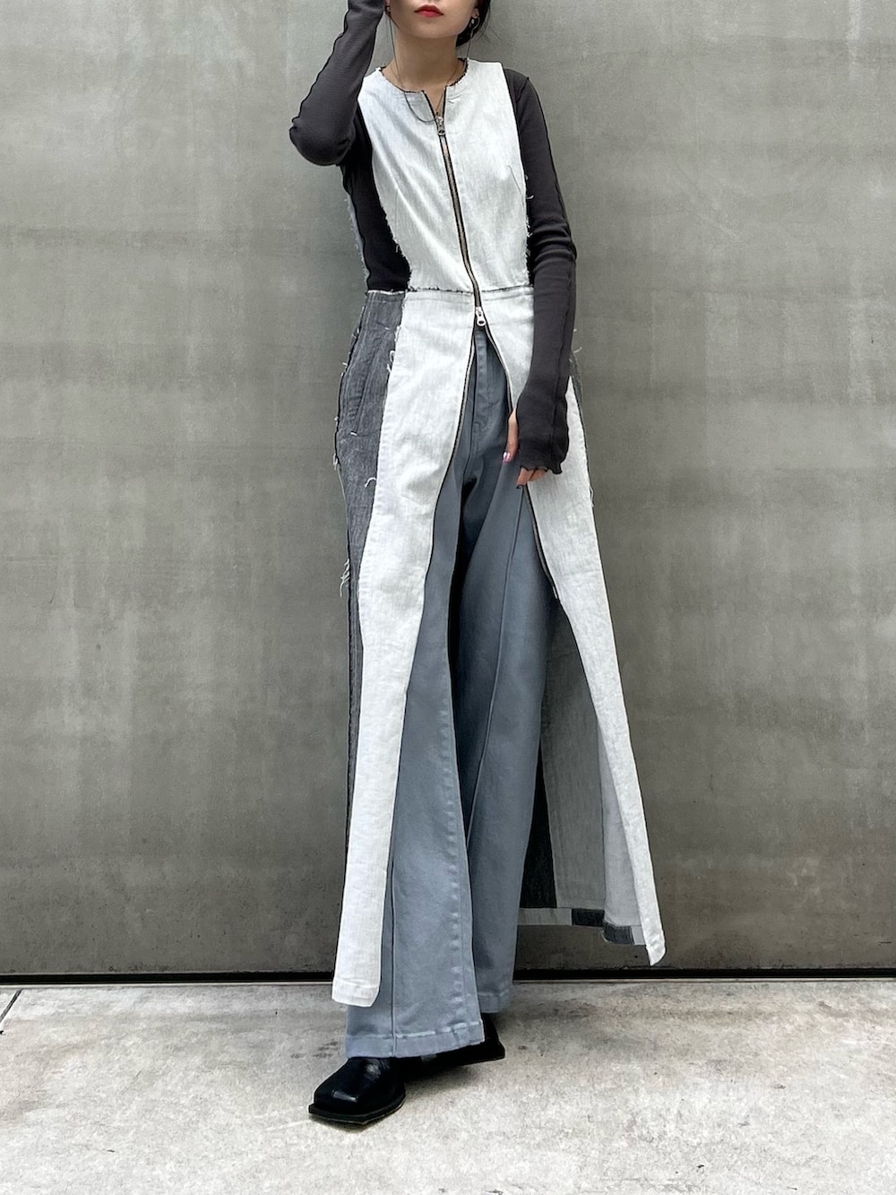 グレー系のTシャツ/カットソー、ブラック系のブーツ、ブルー系のデニムパンツを着用したレディースの秋コーディネートの5枚目の写真