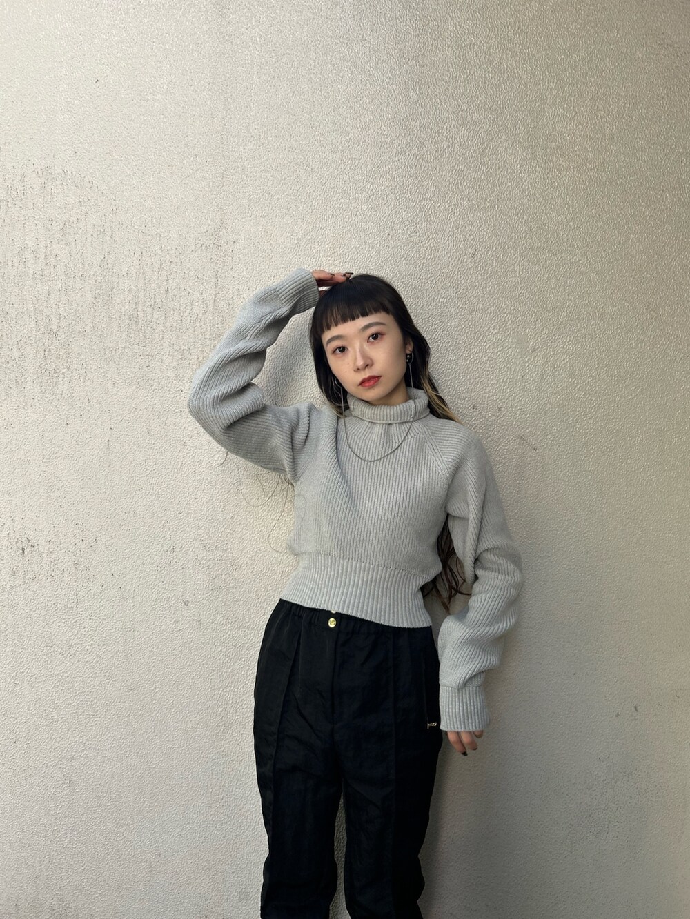 グレー系のニット/セーター、ブラック系のカーゴパンツ、ブラック系のブーツを着用したレディースの秋コーディネートの5枚目の写真