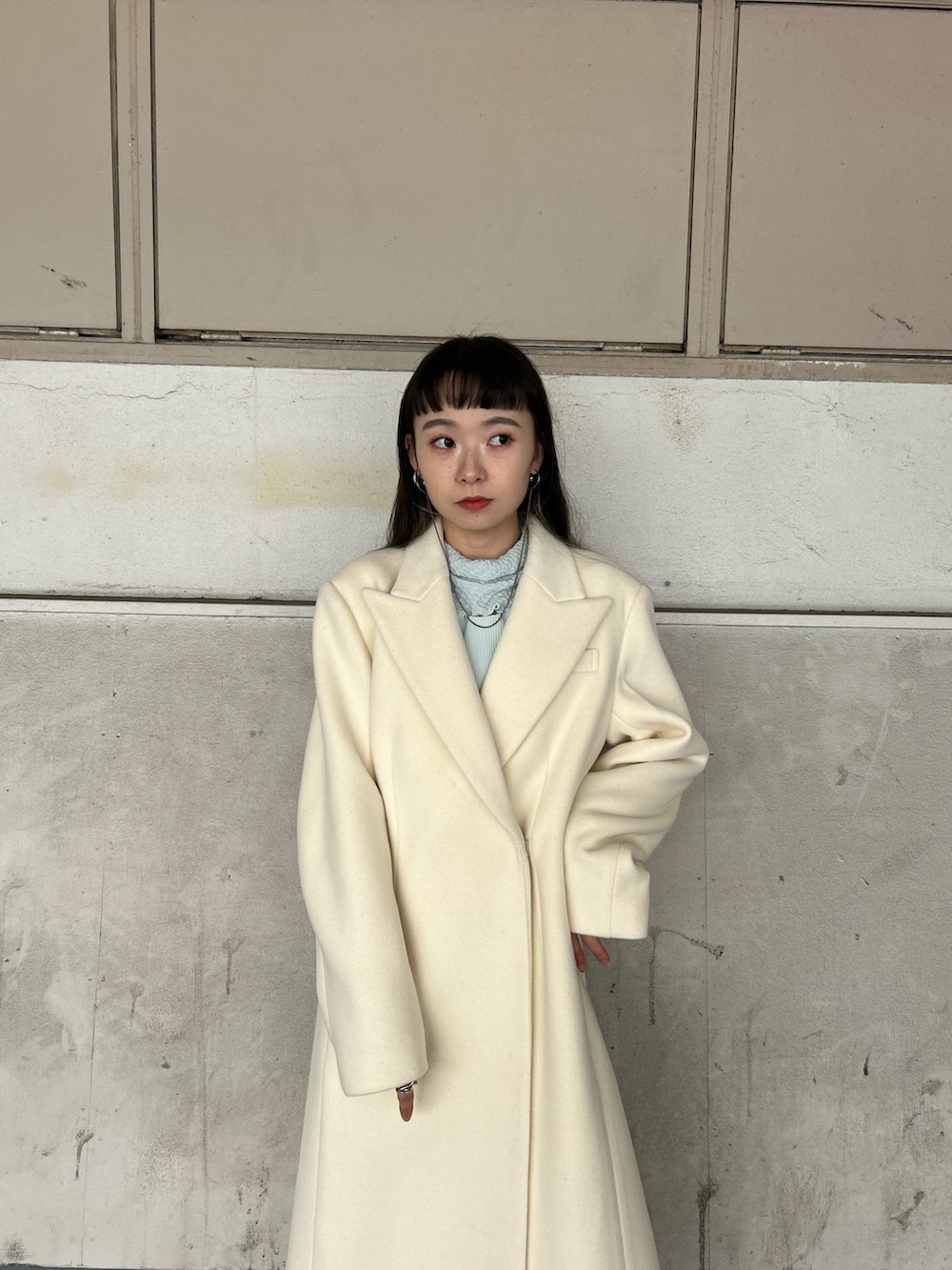 ブラック系のブーツ、ホワイト系のチェスターコート、ブルー系のTシャツ/カットソーを着用したレディースの秋コーディネートの5枚目の写真