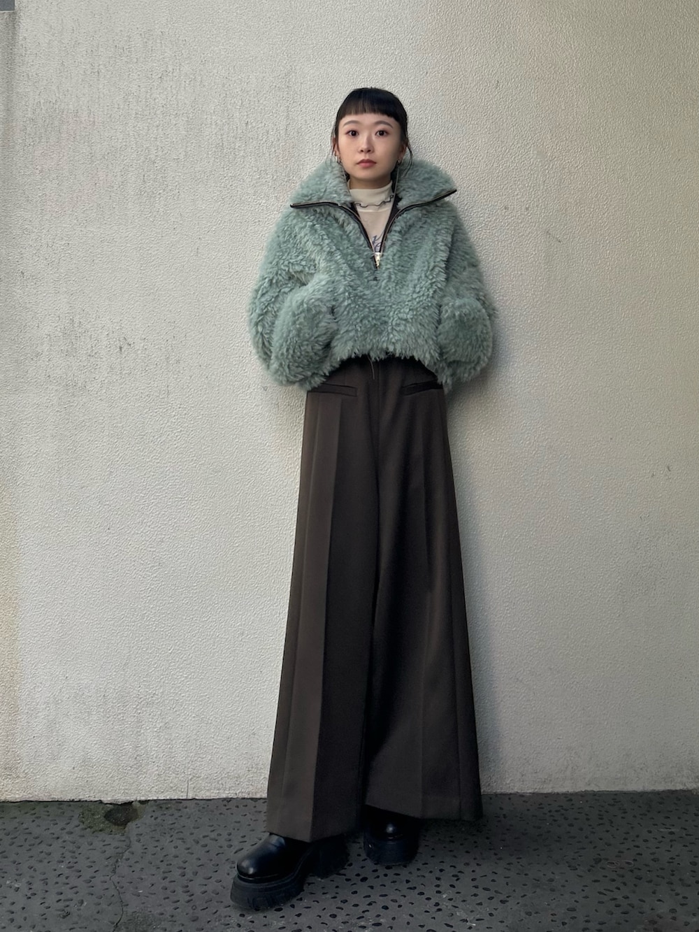 ブラック系のブーツ、ベージュ系のTシャツ/カットソー、グリーン系のブルゾンを着用したレディースの秋コーディネートの4枚目の写真