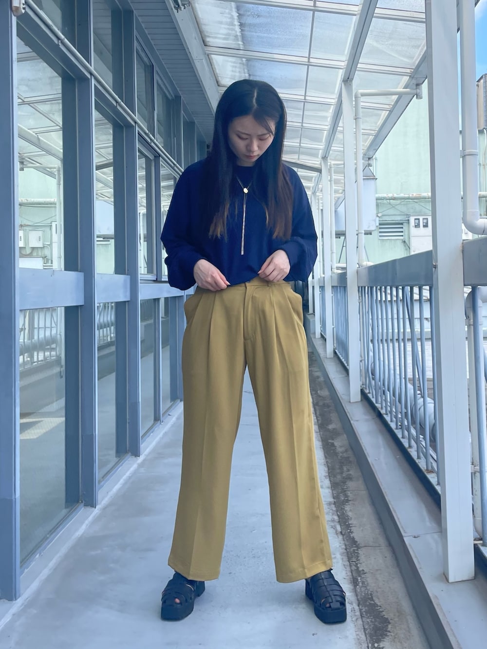 イエロー系のその他パンツ、ブルー系のTシャツ/カットソー、ブラック系のサンダルを着用したレディースの夏コーディネートの2枚目の写真