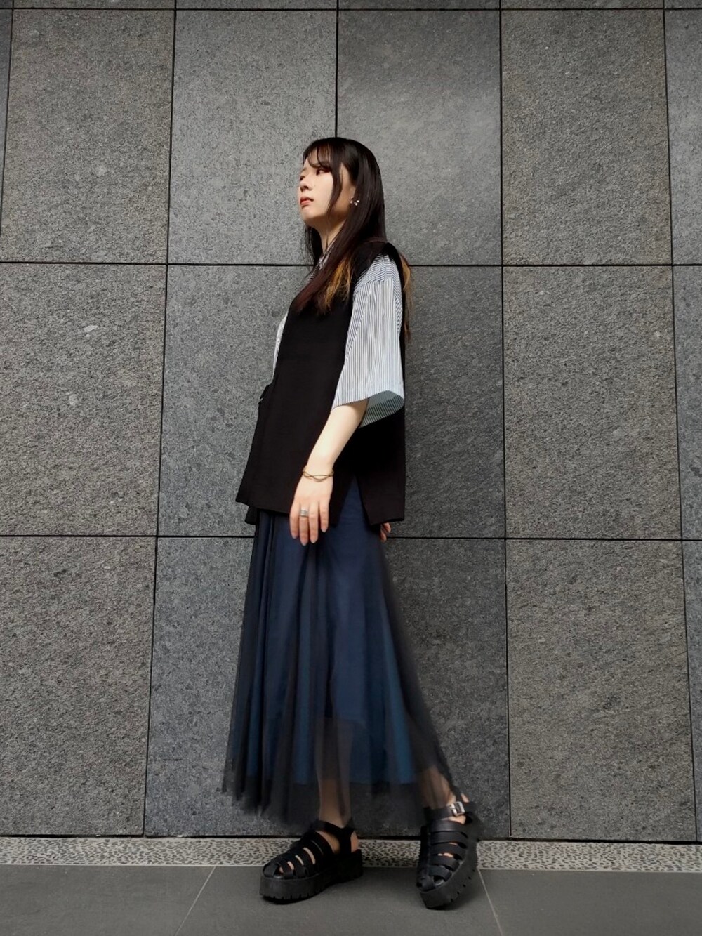 ブルー系のシャツ/ブラウス、ブラック系のベスト、ブラック系のサンダルを着用したレディースの夏コーディネートの3枚目の写真