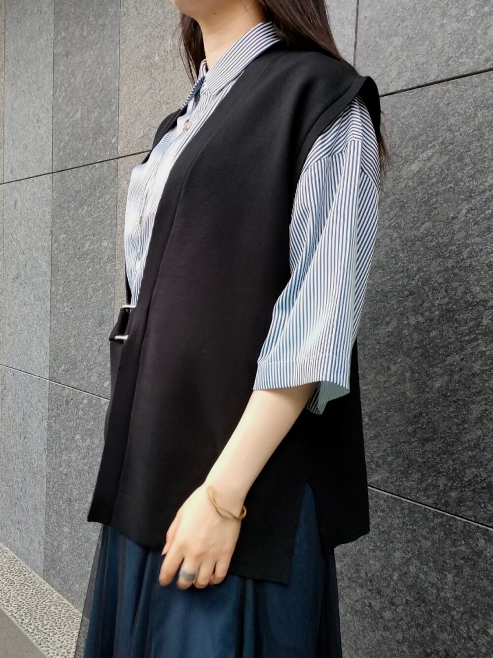 ブルー系のシャツ/ブラウス、ブラック系のベスト、ブラック系のサンダルを着用したレディースの夏コーディネートの4枚目の写真