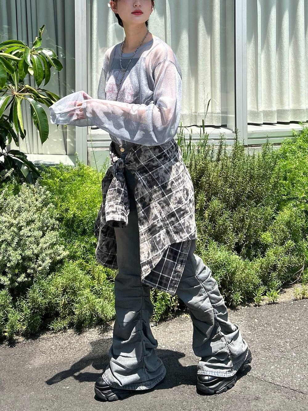 ブラック系のスニーカー、ブルー系のデニムパンツ、ブルー系のニット/セーターを着用したレディースの秋コーディネートの5枚目の写真