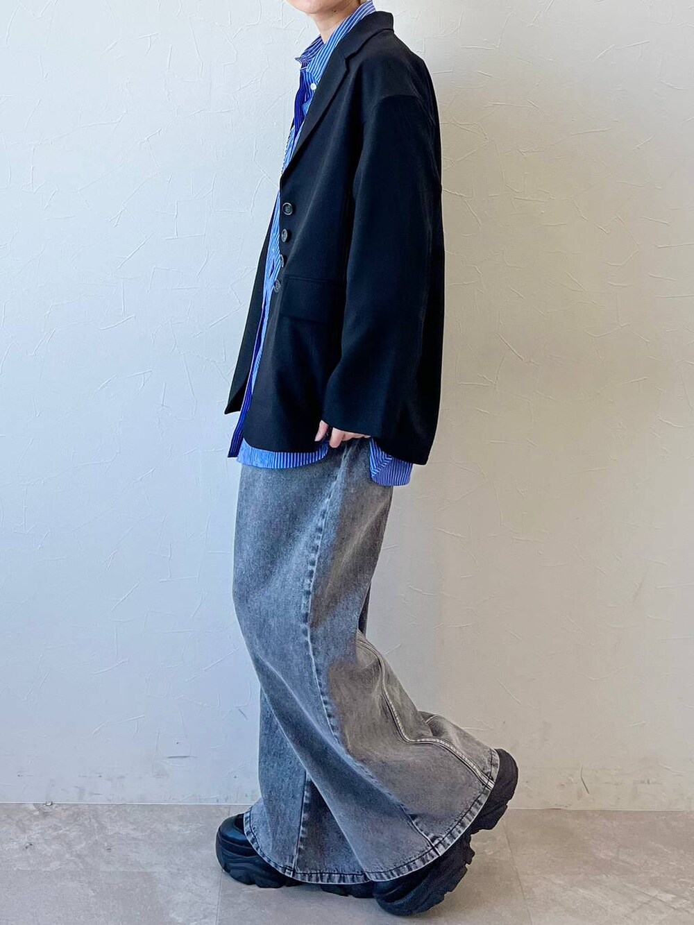 ブラック系のスニーカー、ブラック系のテーラードジャケット、ブラック系のデニムパンツを着用したレディースの春コーディネートの7枚目の写真