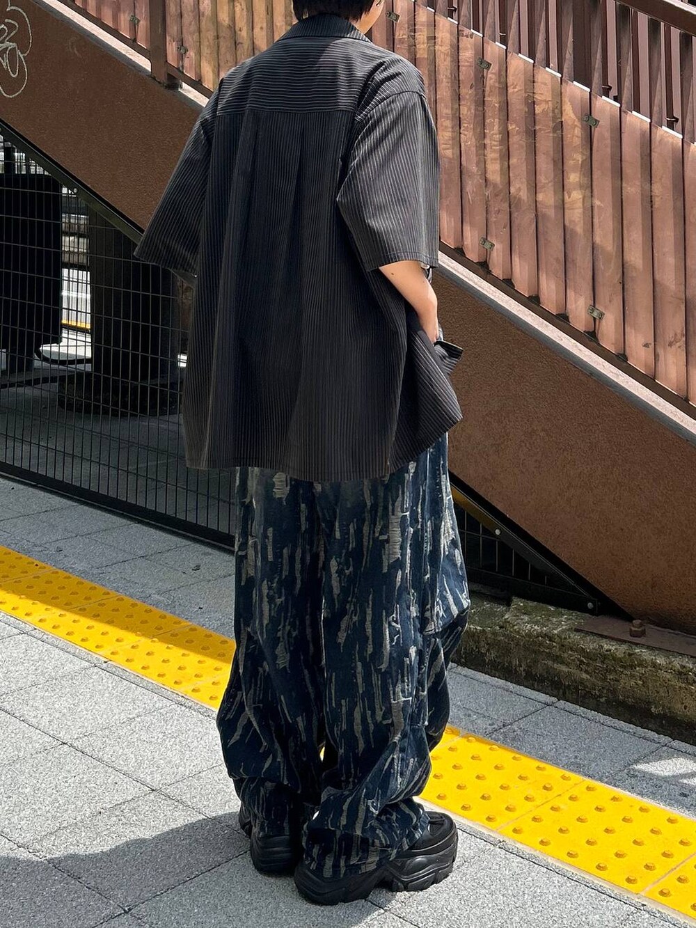 ブラック系のスニーカー、ホワイト系のTシャツ/カットソー、ブラック系のシャツ/ブラウスを着用したレディースの秋コーディネートの6枚目の写真