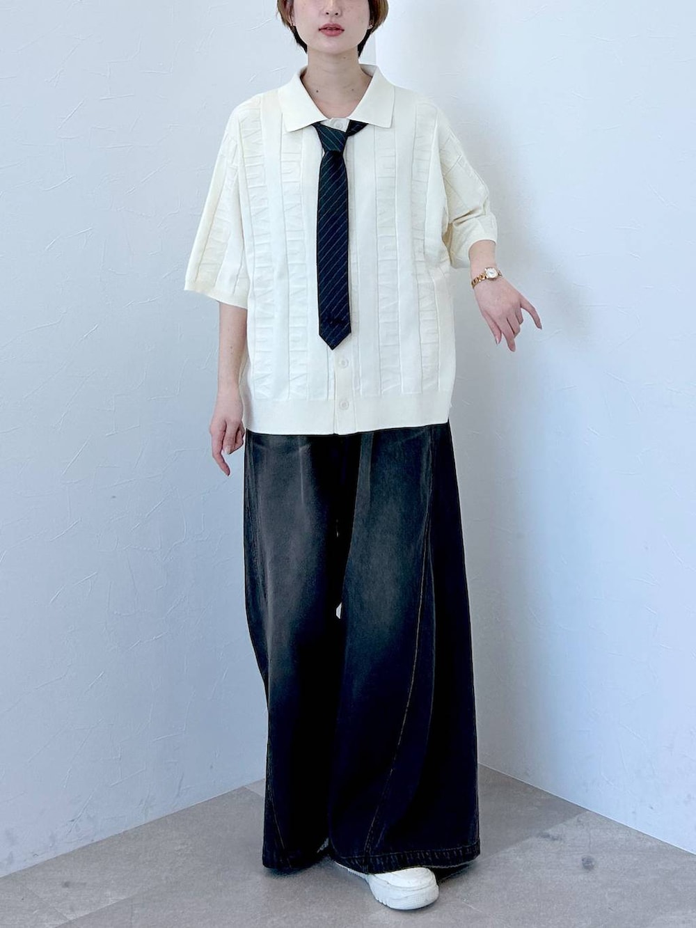 ホワイト系のニット/セーター、ブラック系のデニムパンツ、グレー系のネクタイを着用したレディースの春コーディネートの2枚目の写真